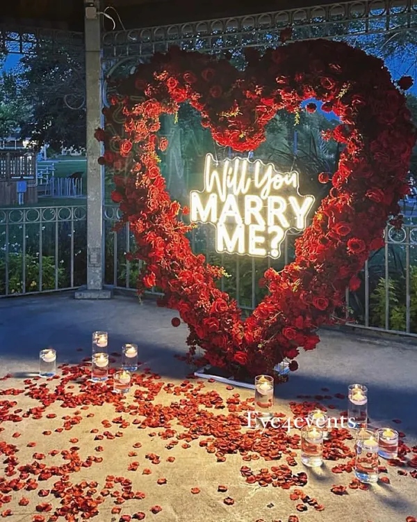 You can never go wrong with classic red roses. This magnificent heart-shaped arch, filled with hundreds of roses and a "Will You Marry Me?" neon sign, creates the ultimate romantic statement.