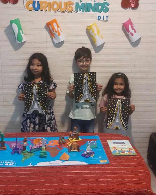 Proudly showing off their Eiffel Tower paintings. Our Wonders of the World session combined learning about global landmarks with a fun dot painting art activity.