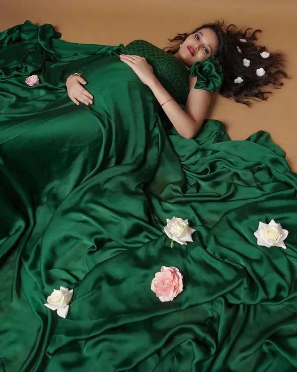 This emerald green satin maternity gown creates a truly stunning visual. The rich fabric drapes beautifully over the baby bump, making it a perfect choice for an artistic and memorable photoshoot.