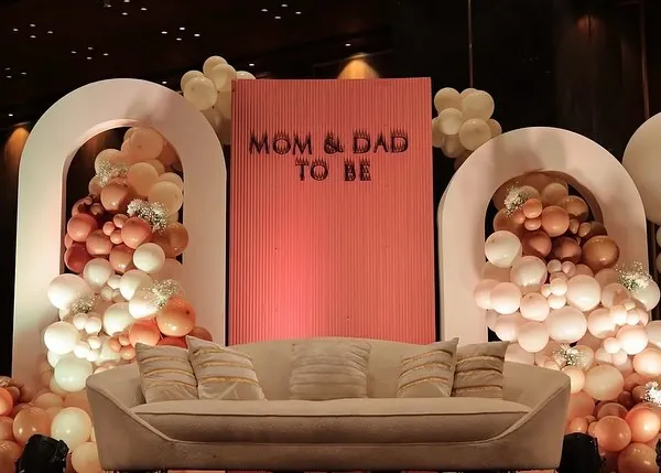 A chic and modern stage for the 'Mom & Dad to Be'. This setup features cascading organic balloon garlands in earthy tones, set against clean, arched backdrops for a sophisticated teddy bear themed baby shower.