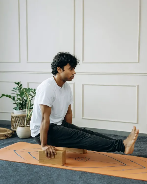 A yoga block isn't a crutch; it's a bridge. Here, it helps build the core and arm strength needed for L-sit (Brahmacharyasana), making a challenging arm balance more approachable.