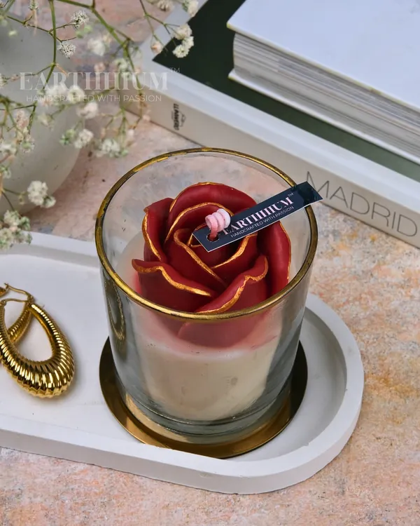 This is my floral votive glass jar candle in a deep, romantic red. The rose is hand-sculpted from wax, and the petals are tipped with gold for an elegant finish.