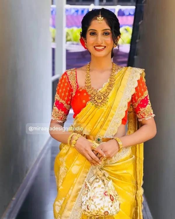 This is what pure joy looks like. I had the pleasure of designing this radiant bride's full muhurtham look, featuring a custom red blouse with delicate zardosi work on the sleeves to complement her stunning yellow Kanjeevaram saree.