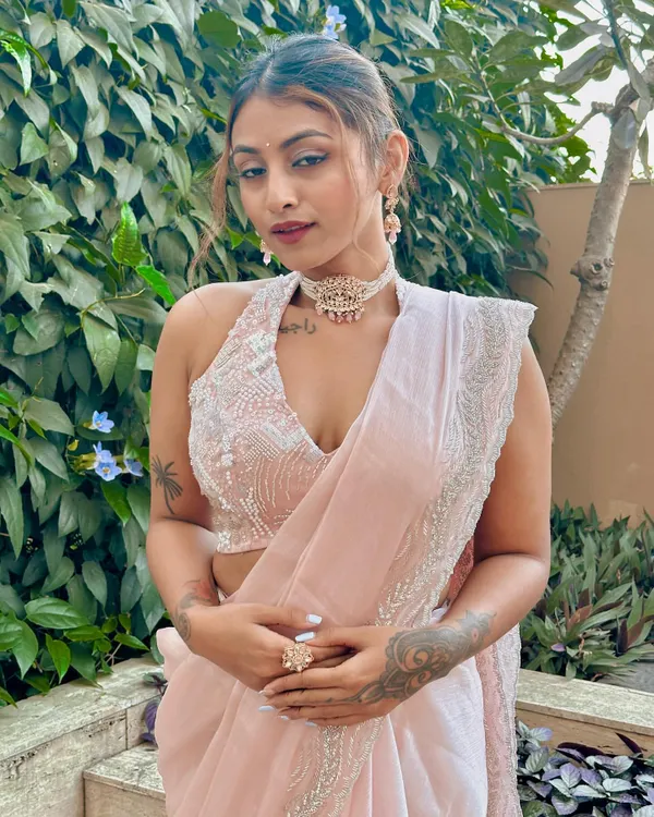 A closer look at this modern festive outfit. The heavily embroidered halter blouse paired with a simple, elegant pink saree and a statement choker creates a balanced and sophisticated Indian wedding look.