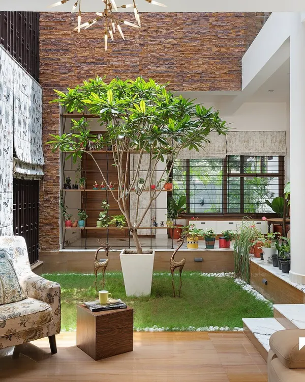 We believe a home's living space should breathe. Here, the formal living room opens directly into a sunken courtyard, where a frangipani tree becomes a natural centerpiece, blurring the line between indoors and out.