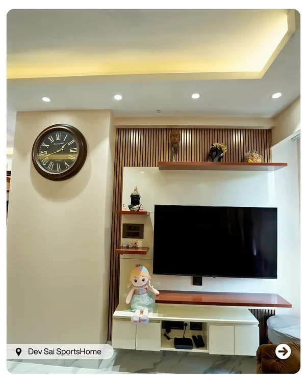 This TV unit combines floating shelves and vertical wooden slats for a clean, modern look. The design provides ample display space while maintaining a light and airy feel in the living area.