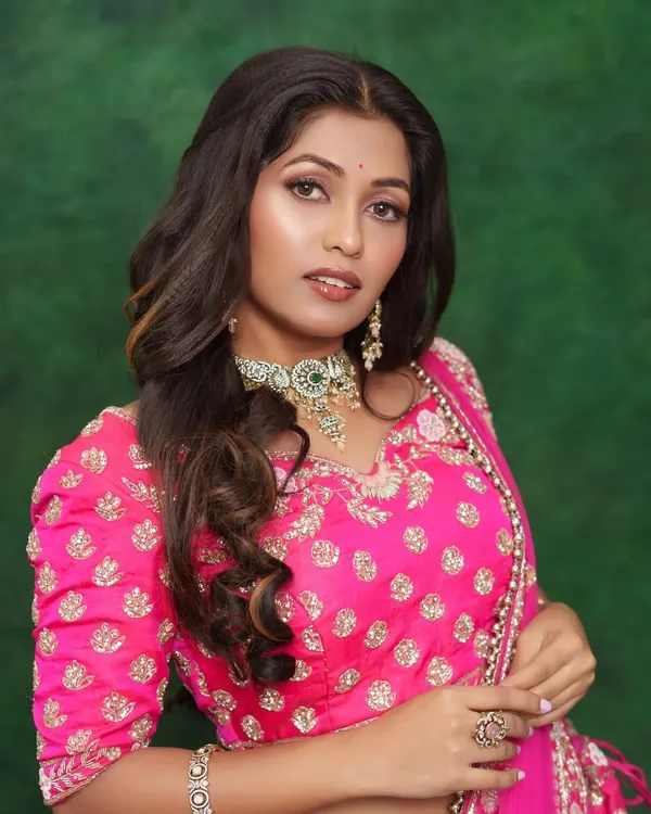 A beautiful "no-makeup" makeup look perfect for daytime events. The focus is on glowing skin, subtly defined eyes, and a neutral lip color, all while wearing a gorgeous pink lehenga.