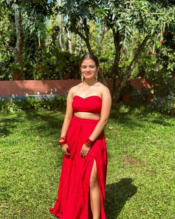This bold red Indo-Western set features a modern sweetheart neck strapless top. It's paired with a matching high-waisted skirt with a thigh-high slit for a contemporary and confident look.