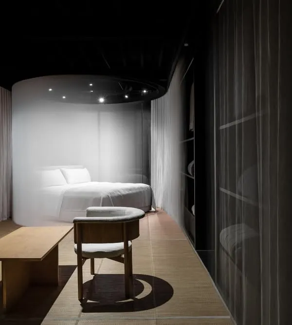 'The Veiled Project', a retail space designed for a luxury bedding brand. Cylindrical pods shrouded in motorized curtains slowly unveil the products, creating an element of surprise and a sense of intimacy for the visitor.