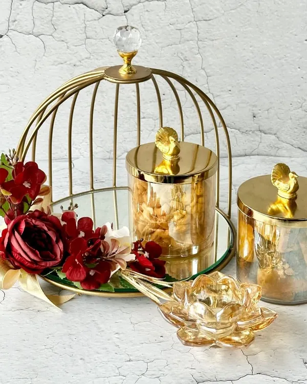 This elegant gold birdcage hamper, filled with gourmet treats and a crystal lotus diya, is a perfect example of how I blend luxury with thoughtful details. It's a statement piece, designed to make any celebration feel truly special.