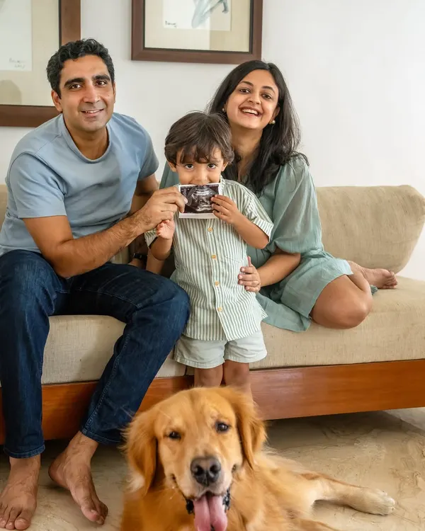 The whole family together, eagerly awaiting their newest member. Here, Ziggy the Golden Retriever joins his family for a maternity announcement, with his human brother proudly showing the sonogram.