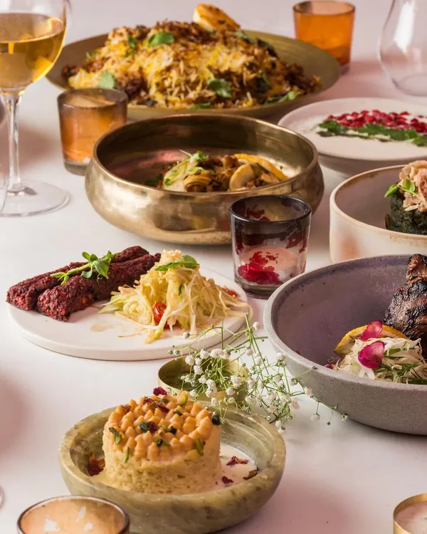 A vibrant spread showcasing the diversity of our Modern Indian menu. Dishes like beetroot kebabs, deconstructed chaat, and jackfruit biryani are presented with contemporary flair.