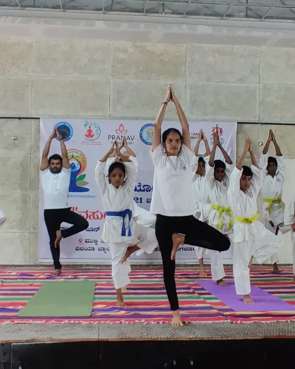 Our students, from young children to adults, practicing Vrikshasana (Tree Pose) on stage during an International Day of Yoga event. Balance is a key skill we cultivate in our martial arts training.