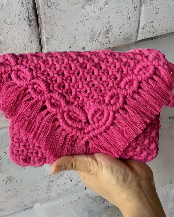 This hot pink sling bag is all about making a statement! The intricate knotting on the flap and the soft fringe make it so special. It's a clutch and a sling bag in one, perfect for adding a pop of color.