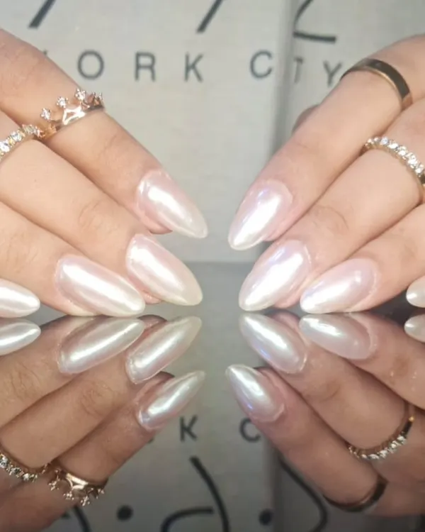 A stunning set of long, stiletto nails with a pearlescent white finish that gives off a beautiful, ethereal glow.