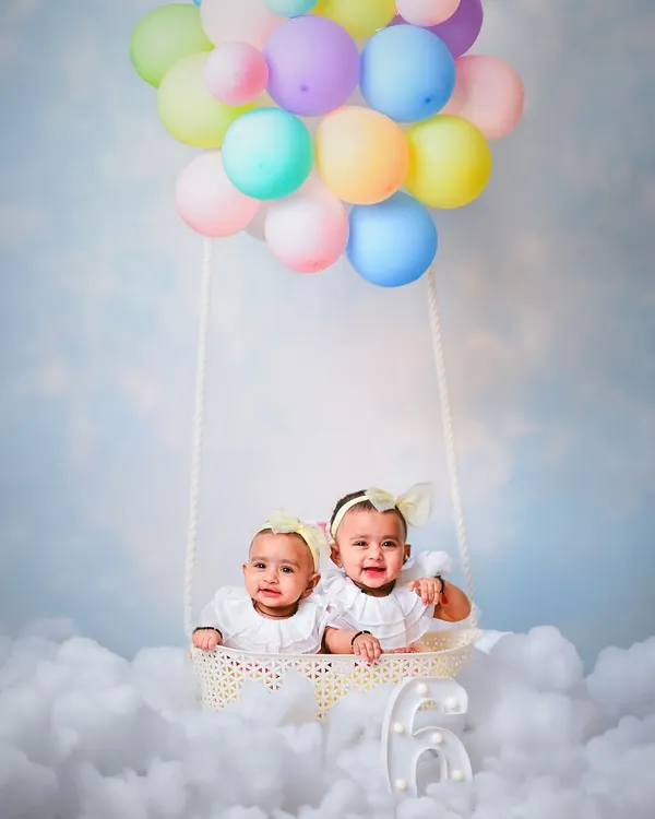 We create magical worlds for your little ones, like this dreamy hot air balloon ride in the clouds for a special twin photoshoot. This setup is perfect for milestone sessions, letting their imaginations soar.