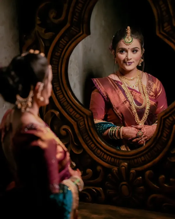 A creative bridal portrait using a mirror to capture the bride's reflection. This adds depth and an artistic touch to the getting-ready photos.