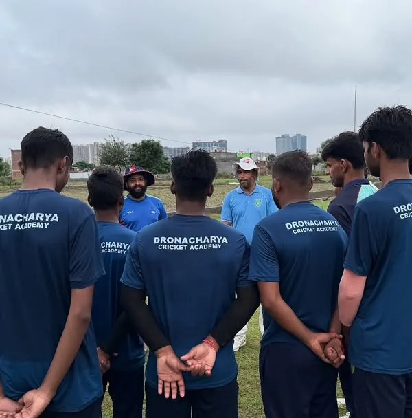 A coach's guidance is the cornerstone of a team's success. Here, our players listen intently during a strategy session, absorbing lessons on game awareness and execution that are vital for competitive cricket.