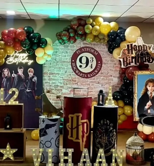 Welcome to Hogwarts! This Harry Potter birthday setup features a Platform 9 3/4 backdrop, balloons in Gryffindor colors, and themed props that capture the magic of the series.