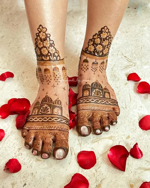Bridal mehndi isn't just for hands. I love adorning feet with designs like this, featuring delicate architectural domes and floral patterns, beautifully framed with scattered rose petals for the perfect shot.