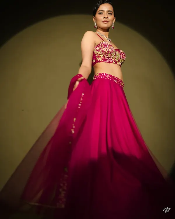 A classy and elegant shot of model Athulya Chandra for a fashion editorial. I created a sophisticated look with a sleek, side-parted hairstyle and glowing skin to complement the vibrant pink lehenga and diamond jewelry.