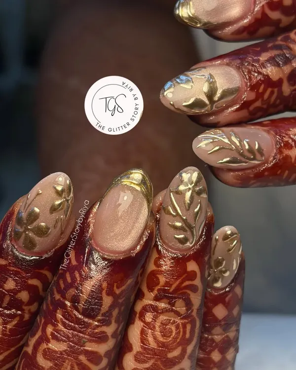 A stunning bridal set designed to complement intricate henna. These nails feature 3D gold leaf art on a neutral base, creating a look of pure opulence for the big day.