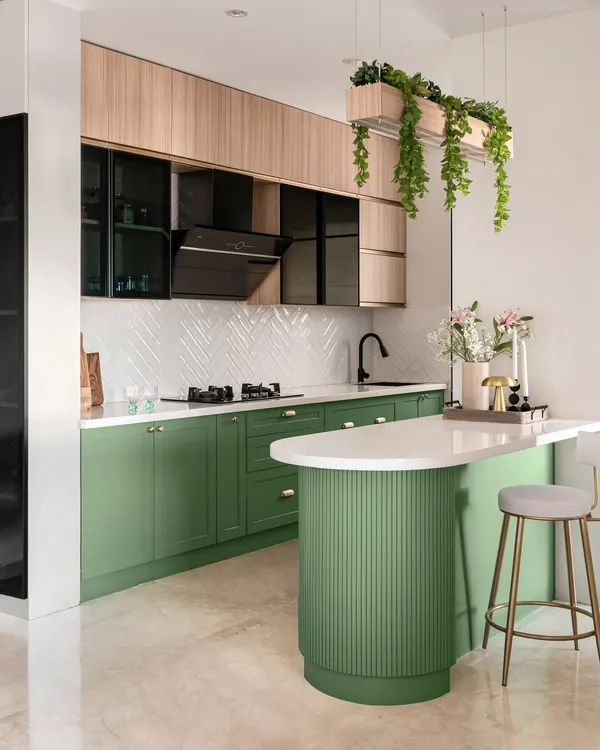 This is a look at a modern galley kitchen we designed, which was featured in Elle Decor. We used a refreshing sage green for the lower cabinets and a natural wood tone for the overhead units, creating a space that feels both vibrant and warm. The design includes a fluted breakfast counter and smart storage solutions to make it as functional as it is beautiful.