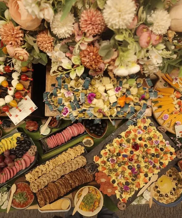 A stunning overhead view of a bespoke grazing table, overflowing with artisanal cheeses, charcuterie, fresh fruits, and gourmet bites. This is where conversations start and memories are made, a true feast for the senses.