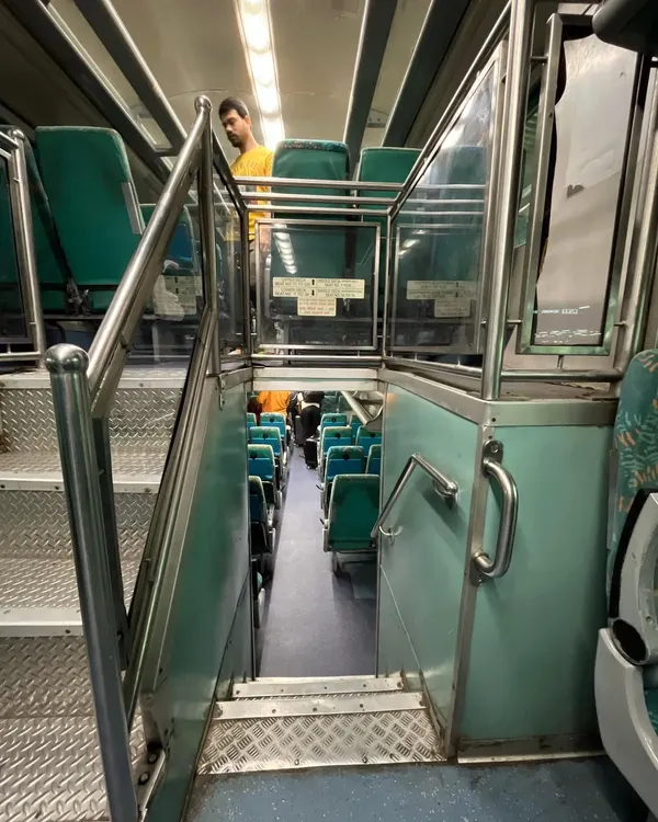 A view from the upper deck looking down the stairs to the lower deck of the Mumbai-Ahmedabad double-decker express train.