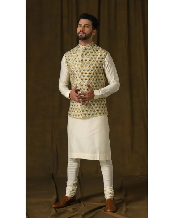 The Lemon Bandi & Ivory Kurta Ensemble. The vibrant lemon vest features intricate floral embroidery, creating a playful and charming look perfect for a daytime celebration.