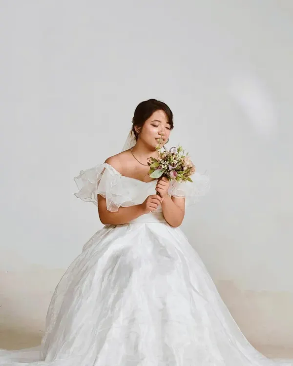 Our white organza ball gown is perfect for creating a dreamy, bridal-inspired look for your pre-wedding shoot. The ruffled off-the-shoulder sleeves add a touch of modern romance.