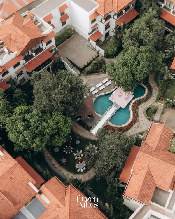 An aerial view of the stunning Rhythm Lonavala resort during Parth and Dhriti's wedding. This drone shot captures the beautiful layout of the venue, including the unique guitar-shaped pool.