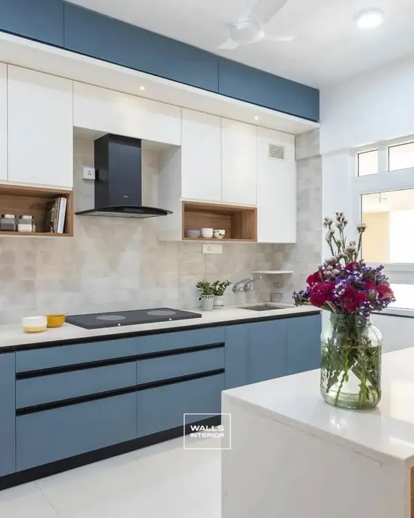 This modern kitchen balances style and function with its popular two-tone design, featuring calming dusty blue base cabinets and crisp white overheads. The spacious island with a clean white countertop serves as both a preparation area and a casual dining spot, making it the heart of the home.