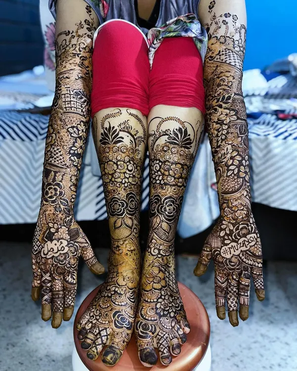 A full bridal look for a Nikah bride, with intricate floral designs covering her hands, arms, and feet for a stunning head-to-toe effect.