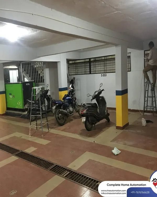 This wide shot shows our team at work in a parking garage of an apartment complex in Vidyaranyapura, installing a comprehensive CCTV network to secure the entire premises.