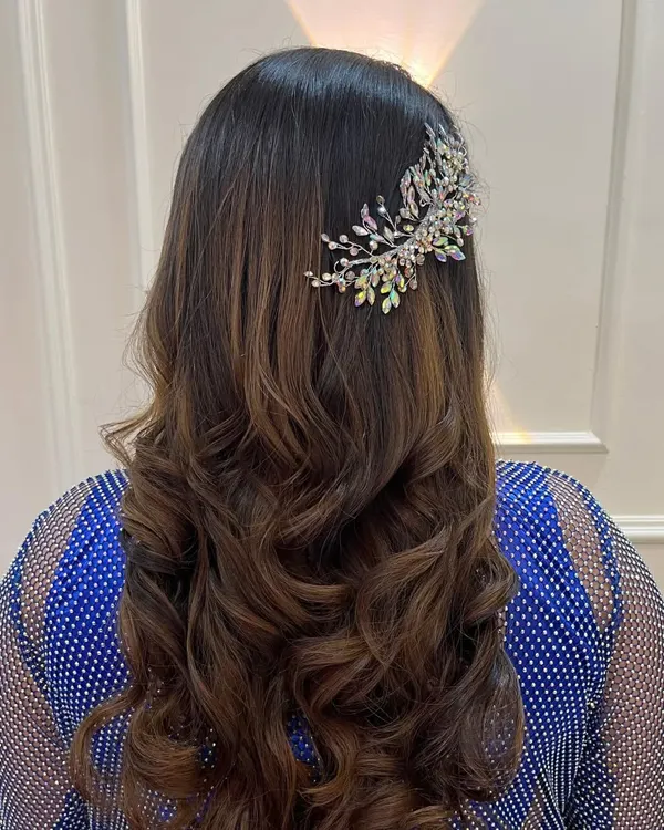 A beautiful hairstyle for a reception or cocktail party. These soft, bouncy curls are accented with a stunning crystal hairpiece, adding a touch of sparkle and glamour.