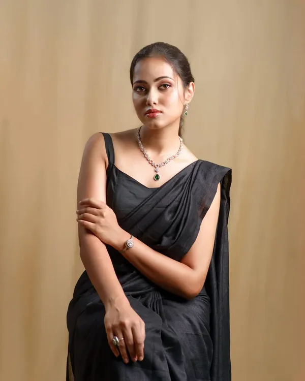 A close-up of the model in the black saree, showing the simple elegance of the outfit and the beautiful jewelry it's paired with.