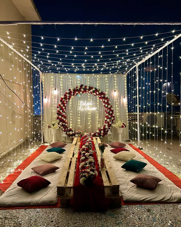This is one of my favorite setups for an intimate evening celebration. I created this magical fairy light canopy on a terrace for a 'Mehndi ki Raat', complete with low seating on wooden pallets, plush cushions, and a custom neon sign. It’s perfect for creating a cozy and unforgettable atmosphere for a bachelorette party, musical night, or any private get-together.