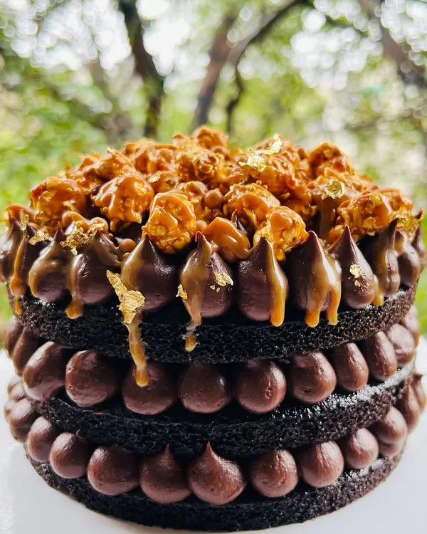 The perfect treat for a rainy day. This is my Chocolate and Salted Caramel naked cake, layered with rich chocolate ganache and topped with crunchy caramel popcorn and a touch of gold leaf.