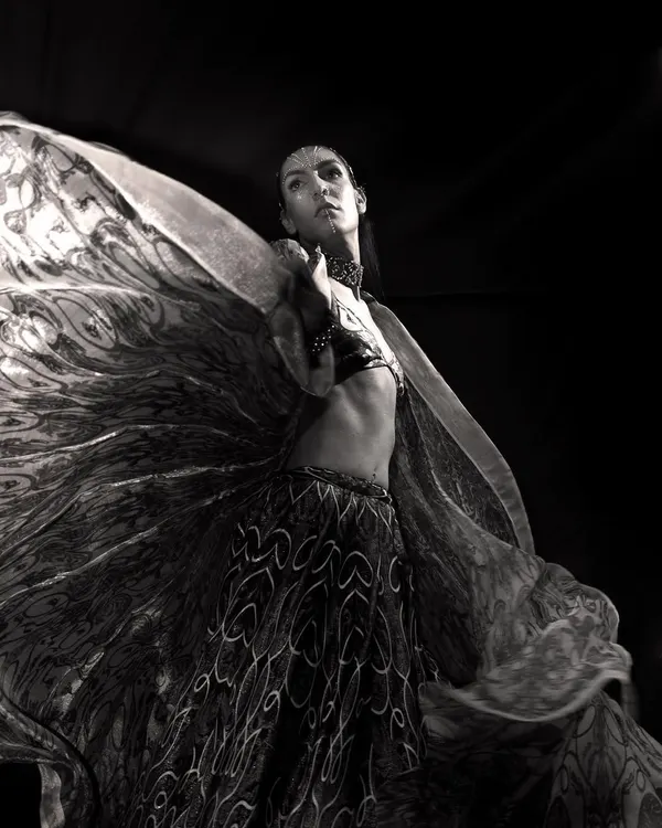 The beauty of monochrome is its ability to capture movement and light. The swirling fabric of the dress creates a breathtaking pattern against the black background, turning a fashion shot into a piece of art.