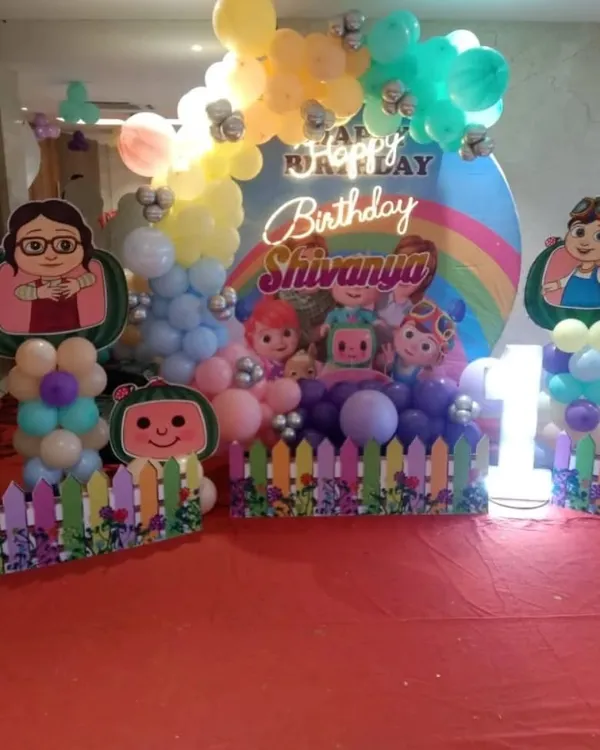 A fun and colorful Cocomelon themed birthday party setup for a child's celebration. I provide the complete decor package, including the character cutouts, balloon arrangements, and a custom backdrop with a neon birthday sign.