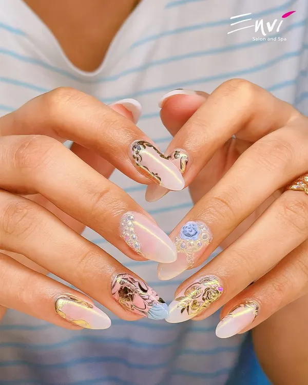 An example of my most detailed work, featuring 3D embellishments like pearls and a delicate blue rose on a base of gold foil and abstract art. This is wearable art for your fingertips.