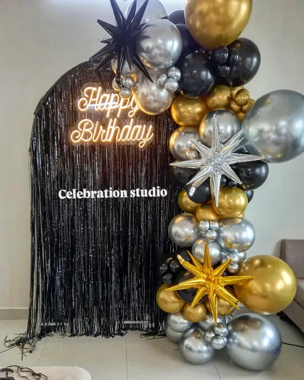 For a truly modern and stylish birthday, I combined a black shimmer wall with a custom neon sign and a dramatic balloon arch in black, silver, and gold. This setup creates a perfect photo backdrop for any milestone celebration.