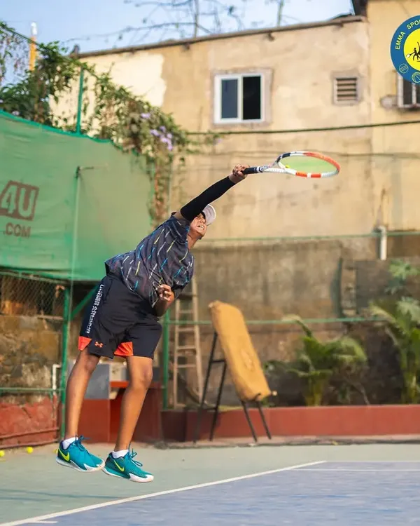 A player is captured at the peak of their serve, demonstrating explosive power and perfect form. This is the kind of technique we help develop on our courts.