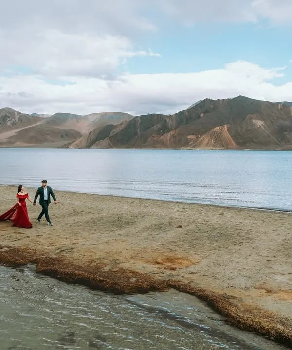 A walk to remember along the serene banks of Pangong Lake in Ladakh. The vast landscape emphasizes the couple's journey together.