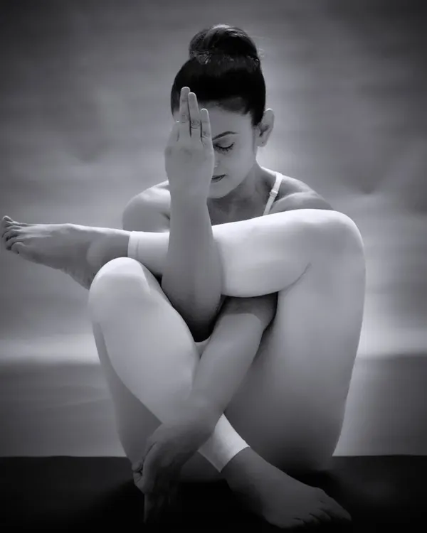 A moment of quiet contemplation in Garudasana, or Eagle Pose. This monochrome photo captures the internal focus and zen-like state that a dedicated yoga practice can bring.