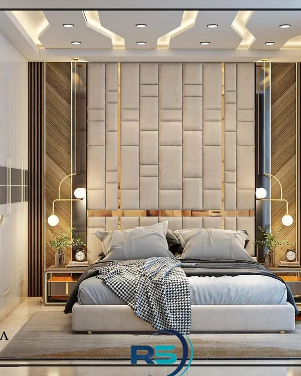 A master bedroom design featuring a floor-to-ceiling upholstered headboard with geometric patterns. The mix of wood paneling, mirror accents, and warm lighting creates a luxurious and inviting atmosphere.