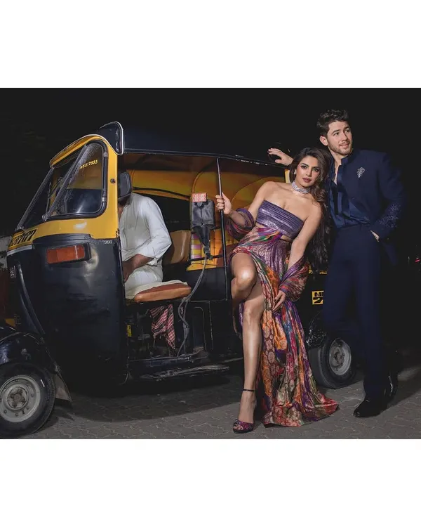 A confident and glamorous portrait of Priyanka Chopra and Nick Jonas. This shot, taken on the streets of Mumbai with an auto-rickshaw, blends high fashion with a distinctly local, candid energy.