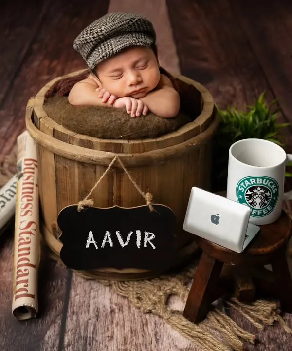 Meet the little boss! This fun, themed setup includes a mini laptop, a coffee mug, and a newspaper to create a playful "boss baby" portrait, perfect for a name reveal.