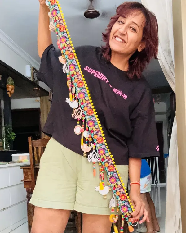 Here I am, so happy holding up the finished 'Tamaara' toran. It’s a celebration of beauty and tradition, with lotus and bird artwork, soft tassels, and ghungroos that sing with every breeze.